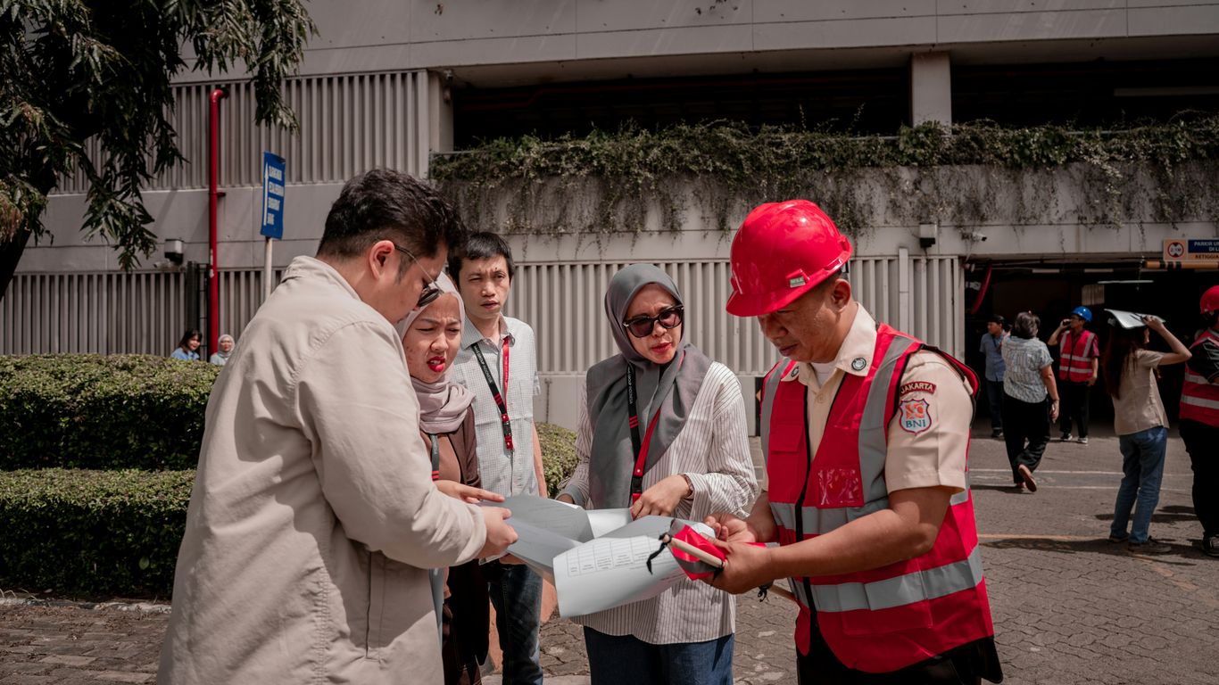 People gathered around blueprints outdoors