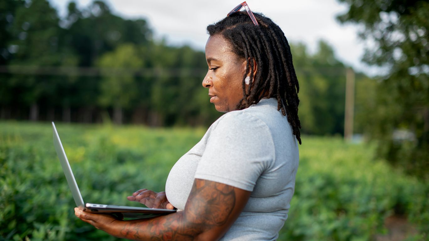 Woman using a laptop in a field