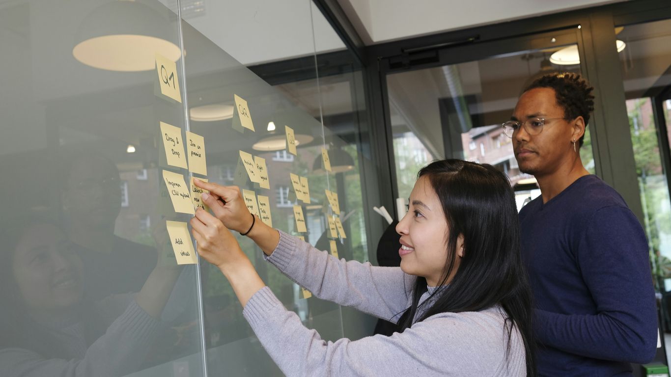 woman in gray sweater holding gold iphone 6