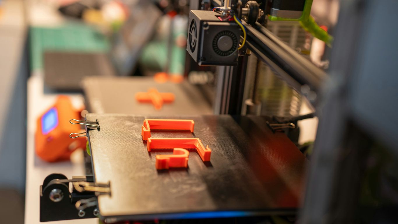 a close up of a machine with orange pieces on it