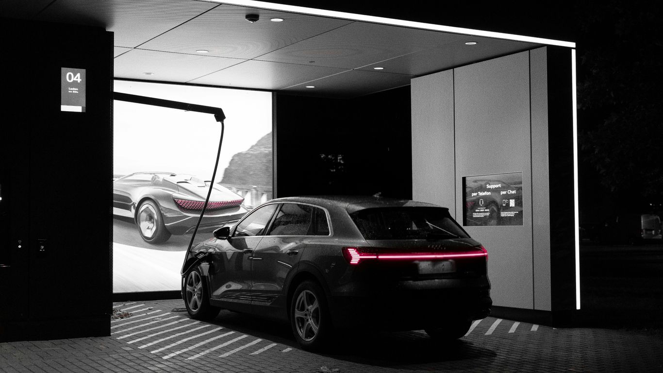 Modern car at a sleek, futuristic showroom at night.