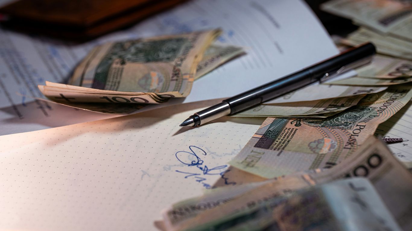 Pen and money scattered on documents