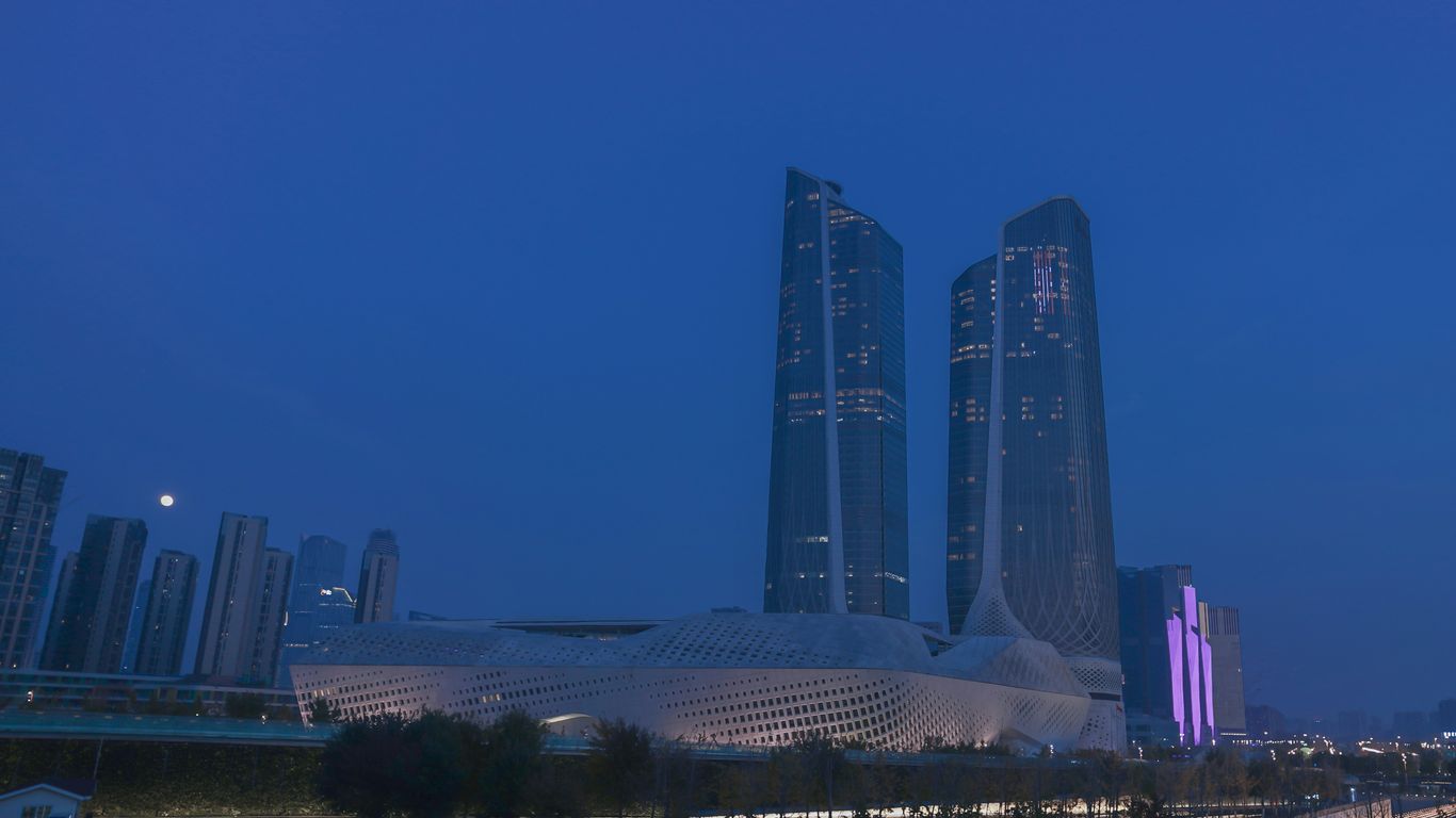 a city skyline at night with tall buildings in the background