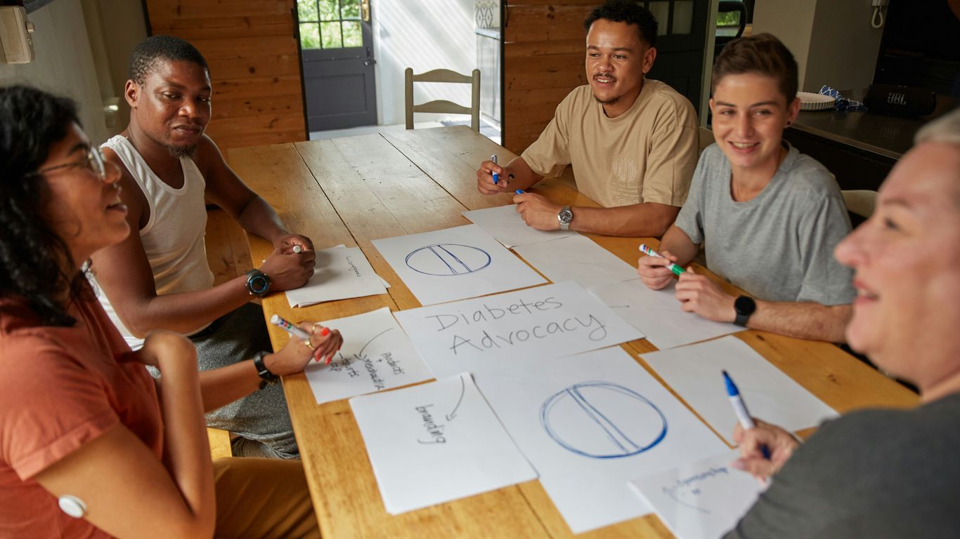 a group of people sitting around a wooden table