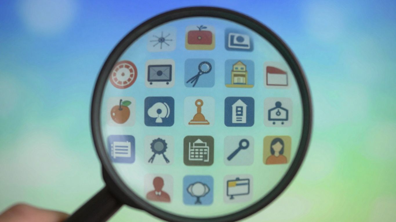 Magnifying glass over digital icons for keyword research.