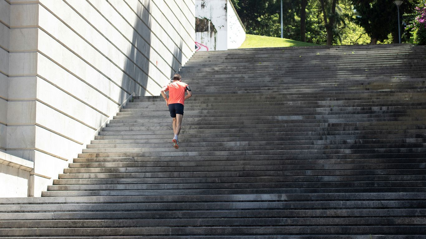 girl in pink shirt and blue shorts walking on wooden pathway