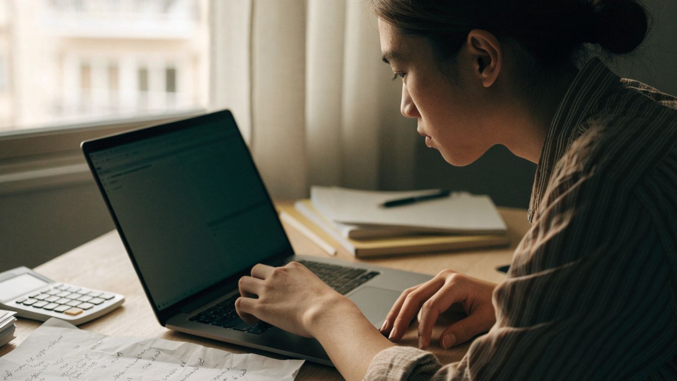 A trader reviewing account details beside a laptop