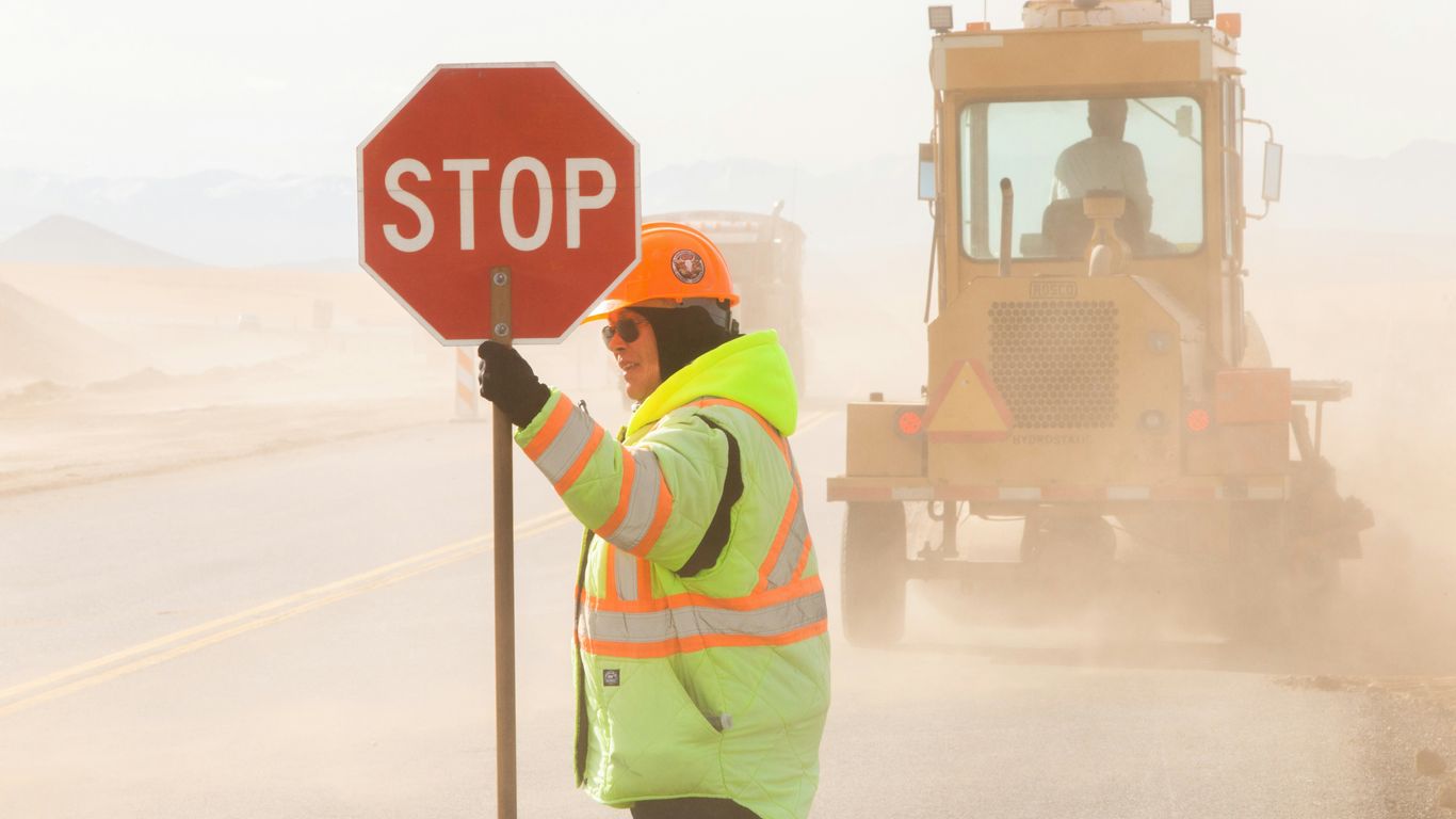 A worker carefully installing a new office sign