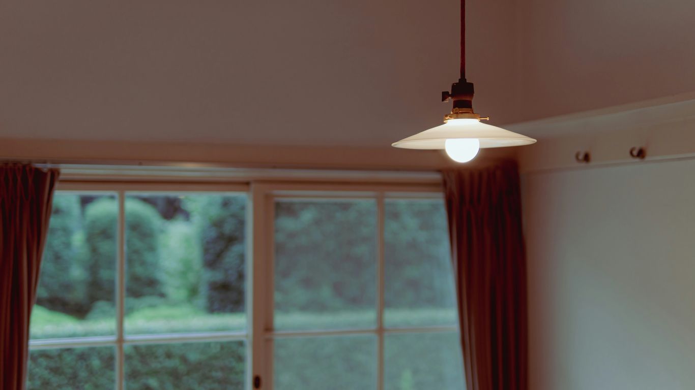 a light hanging from a ceiling in front of a window