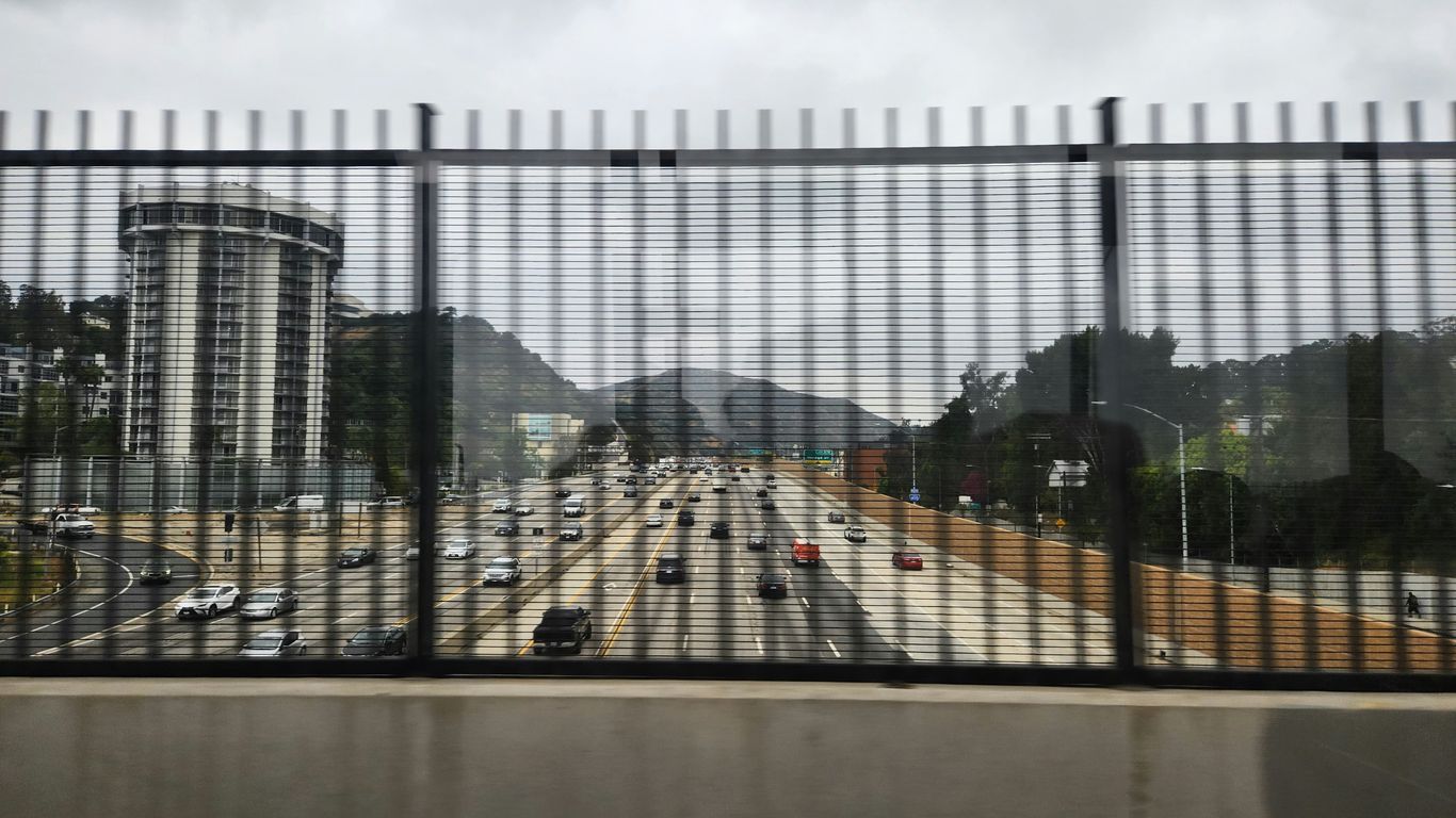 a view of a highway through a fence
