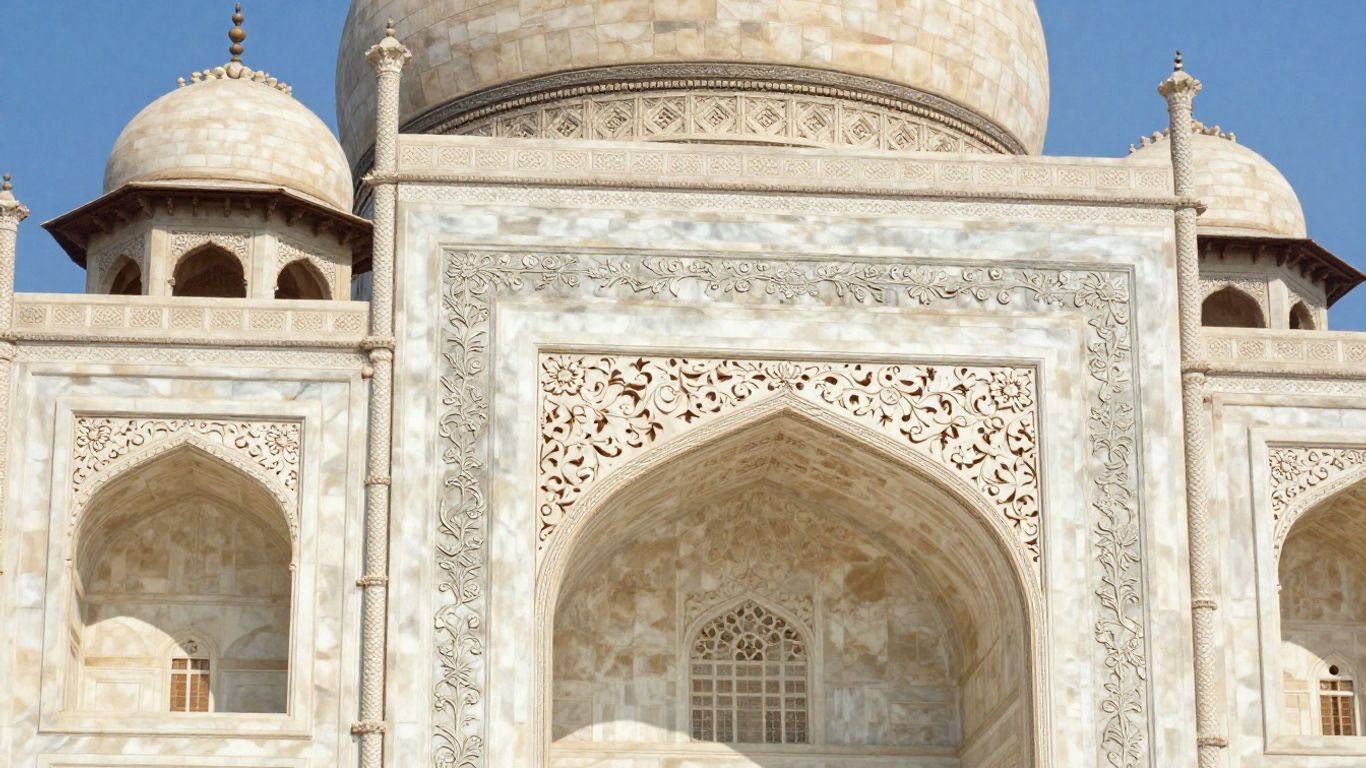 Taj Mahal marble facade with intricate floral carvings.