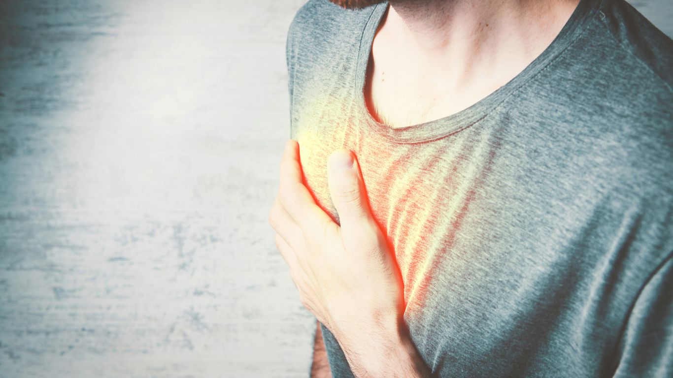 a man holding his chest with his hands