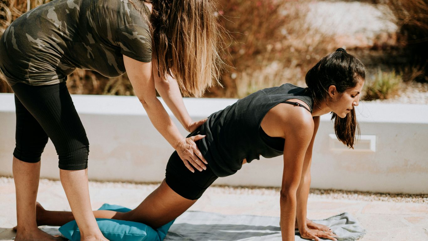 woman in black tank top and black shorts kneeling on mat