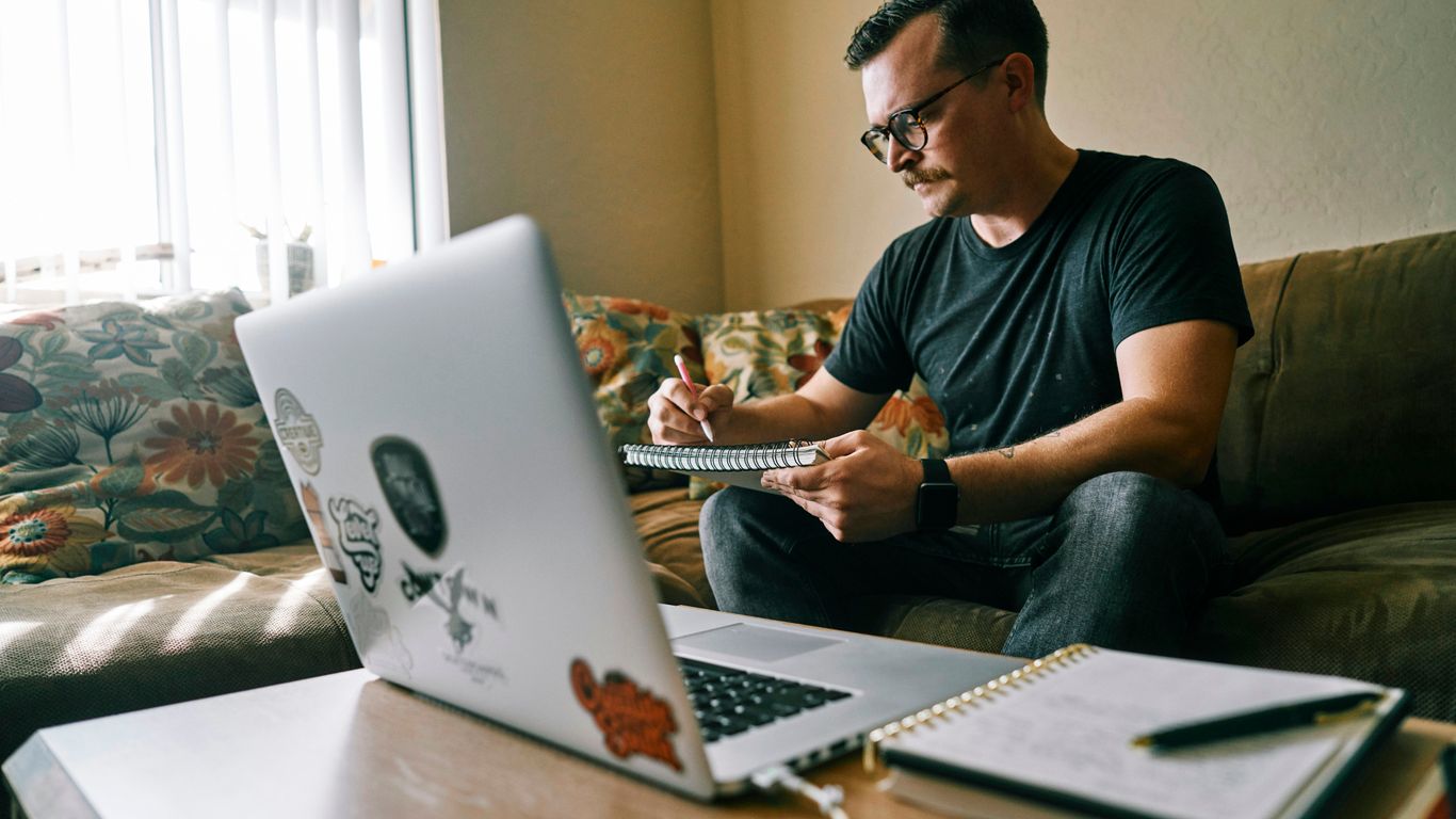man in black crew neck t-shirt using macbook