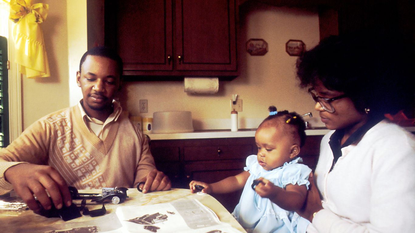 man and woman with child sitting beside table