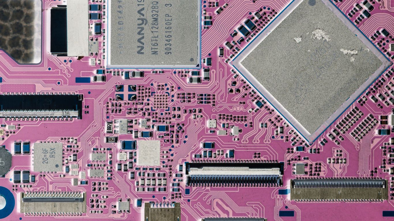 Close-up of a pink circuit board with electronic components.