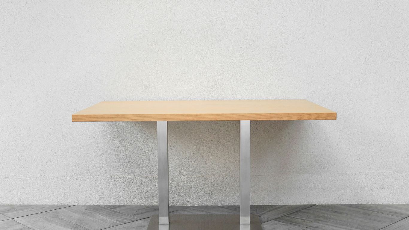 a wooden table sitting on top of a tiled floor