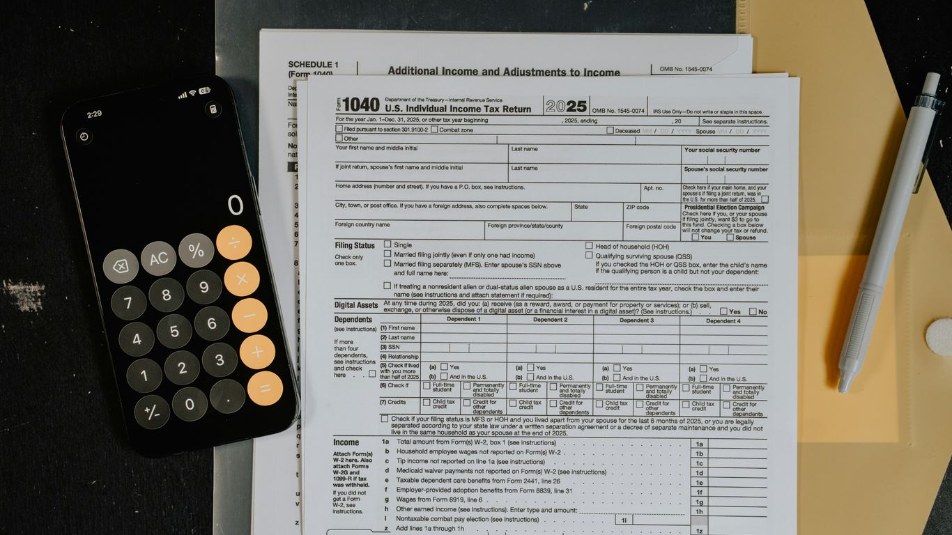 Tax forms and calculator on a desk.