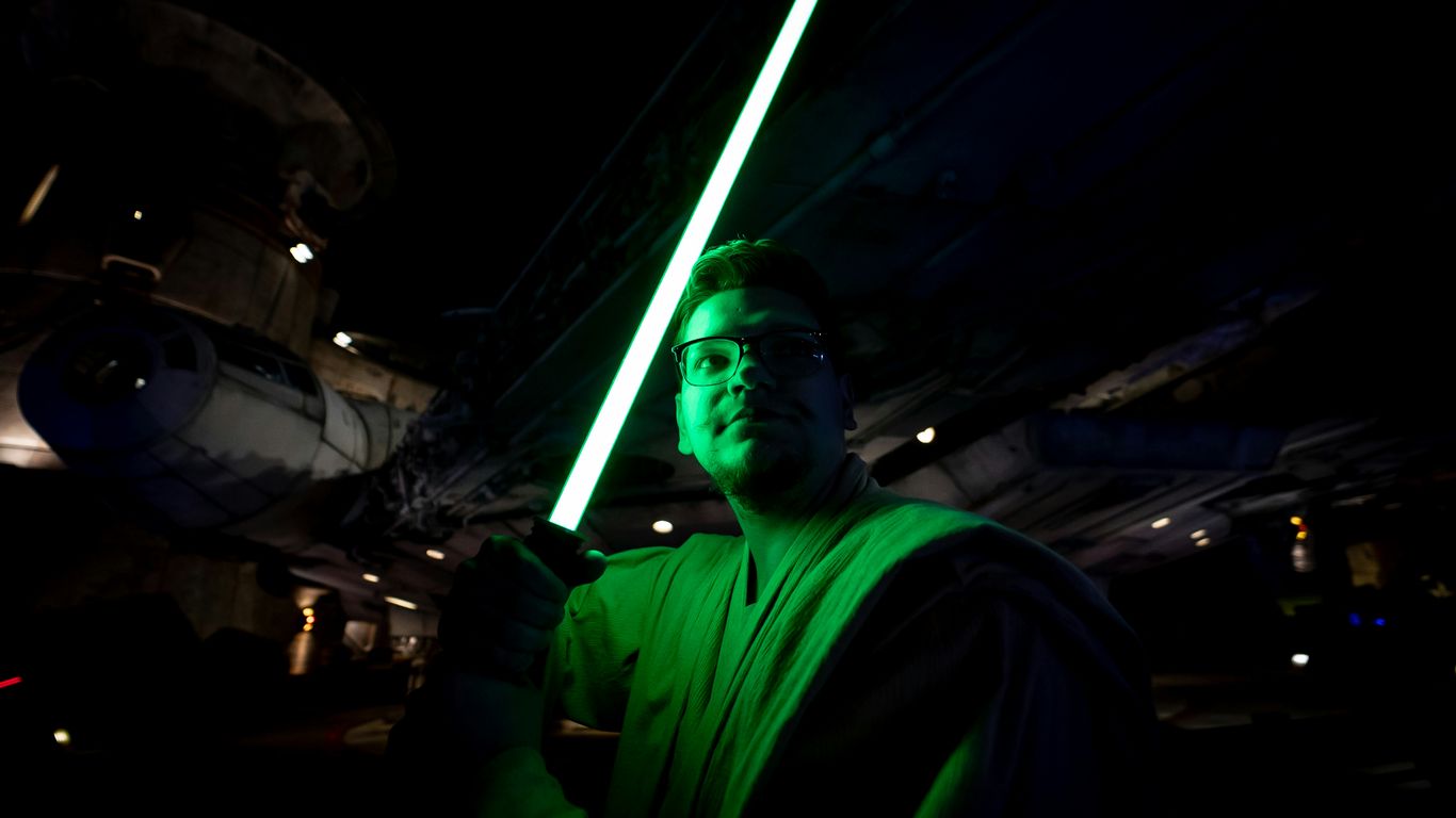 a man holding a light saber in a dark room