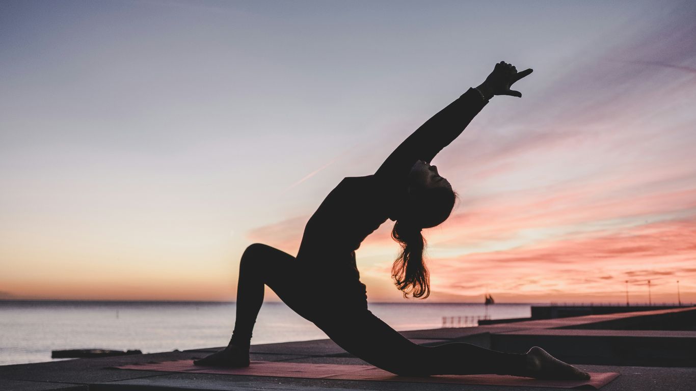 Traveler practicing yoga beside a bright window