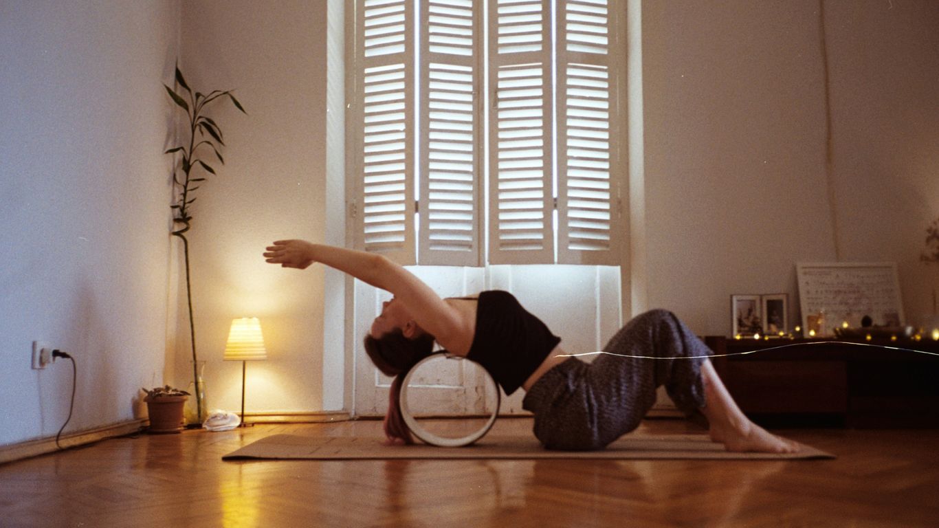 A woman is doing a yoga pose on a mat