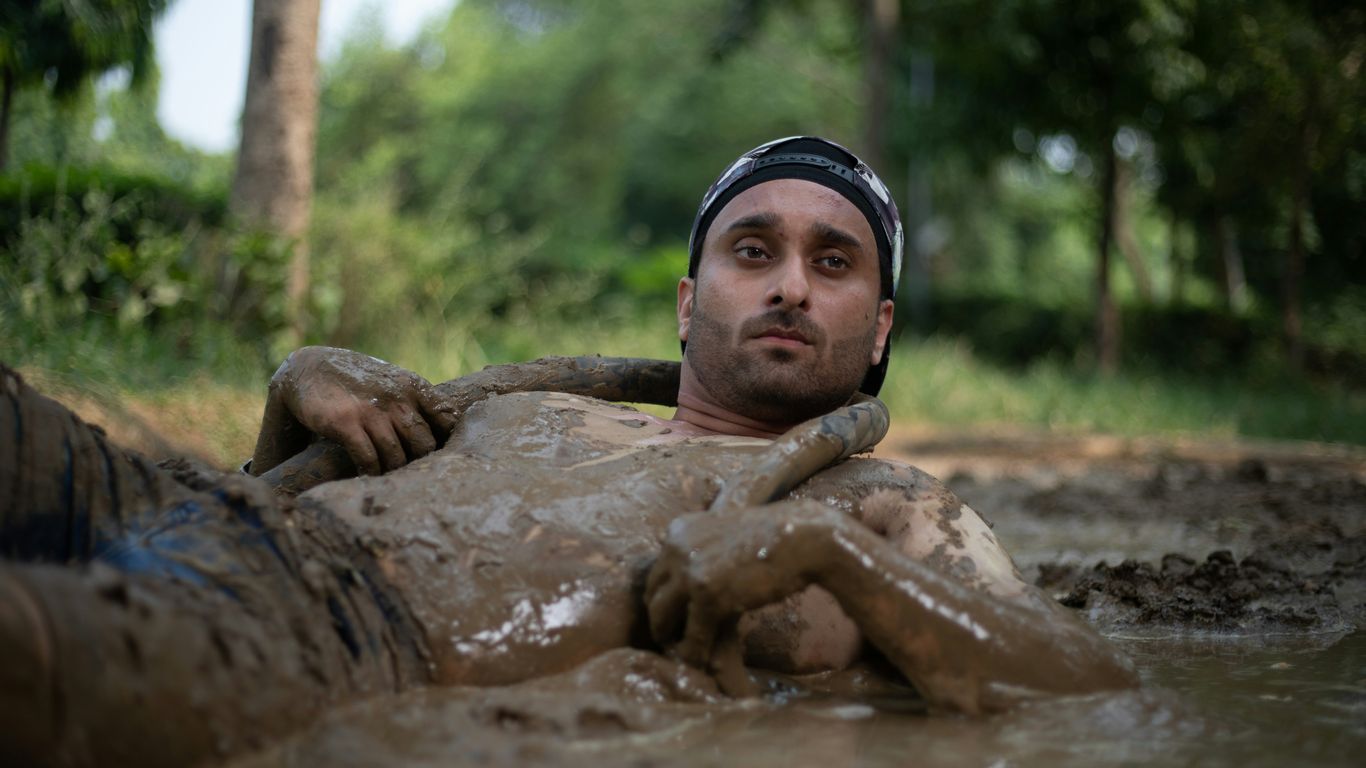 a man laying in the mud in a river