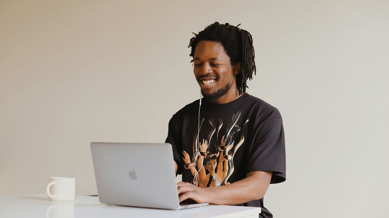 man in black crew neck t-shirt using macbook