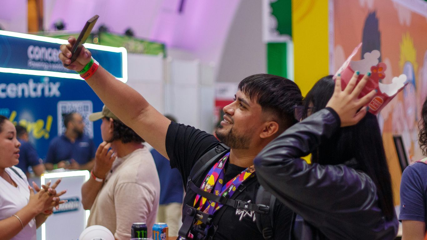 Man taking a selfie with a mask at an event.
