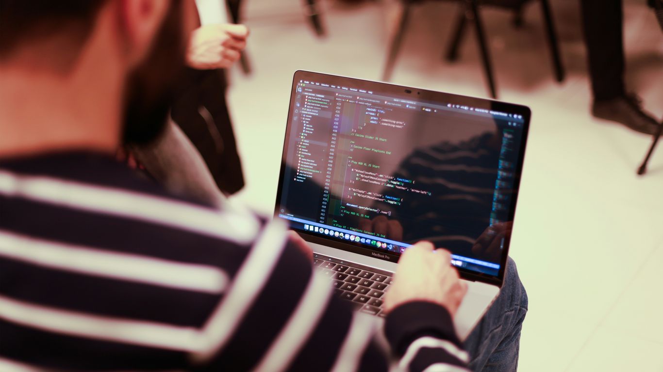 a man sitting in front of a laptop computer
