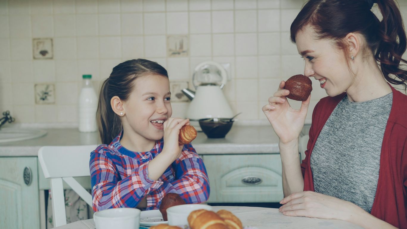 Mother and daughter enjoy breakfast together.
