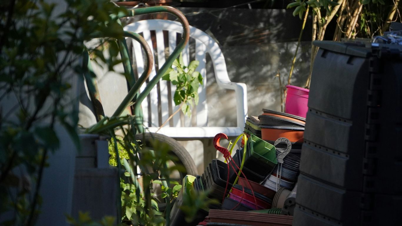White plastic chair with plants and garden items