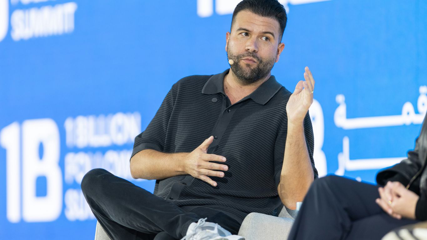 Man speaking on a panel with a blue background