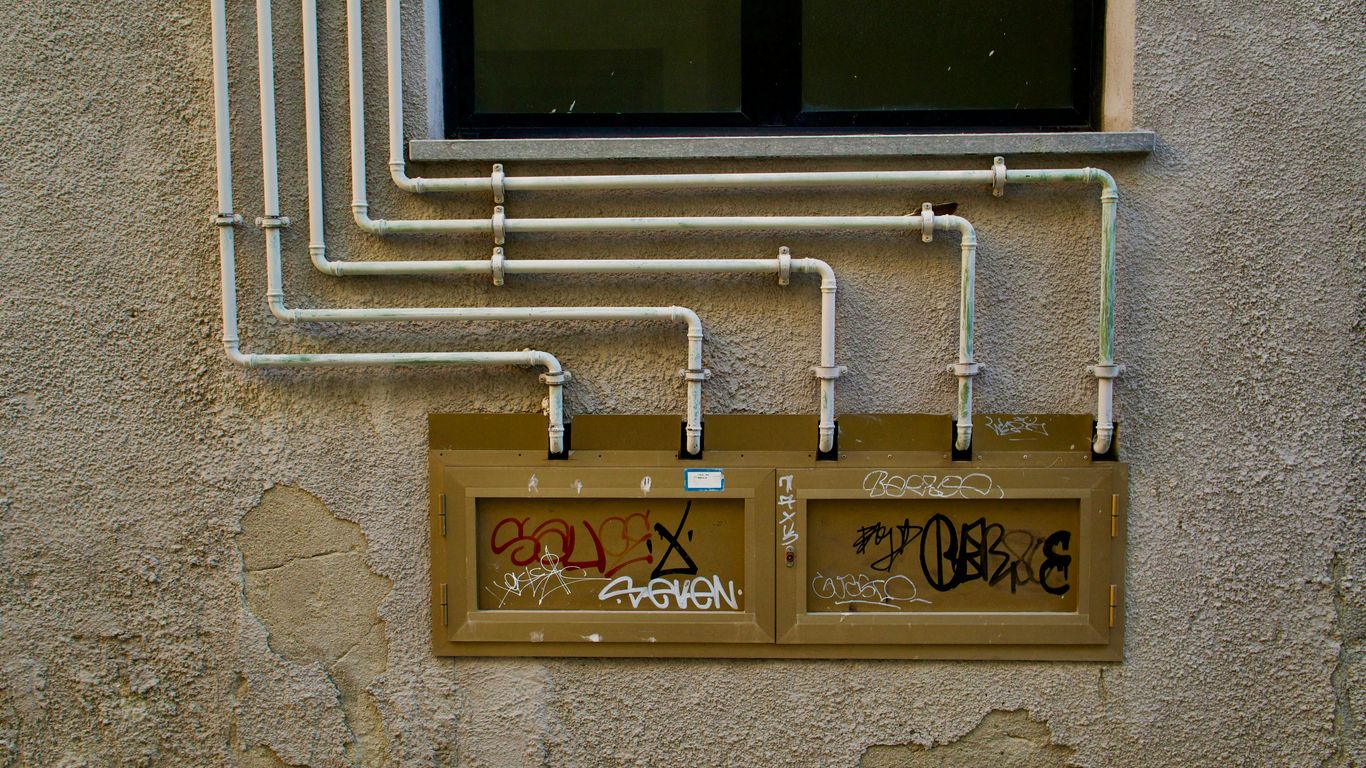 A wall with a bunch of pipes attached to it
