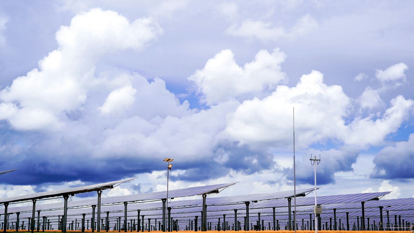 Rows of solar panels under a cloudy sky