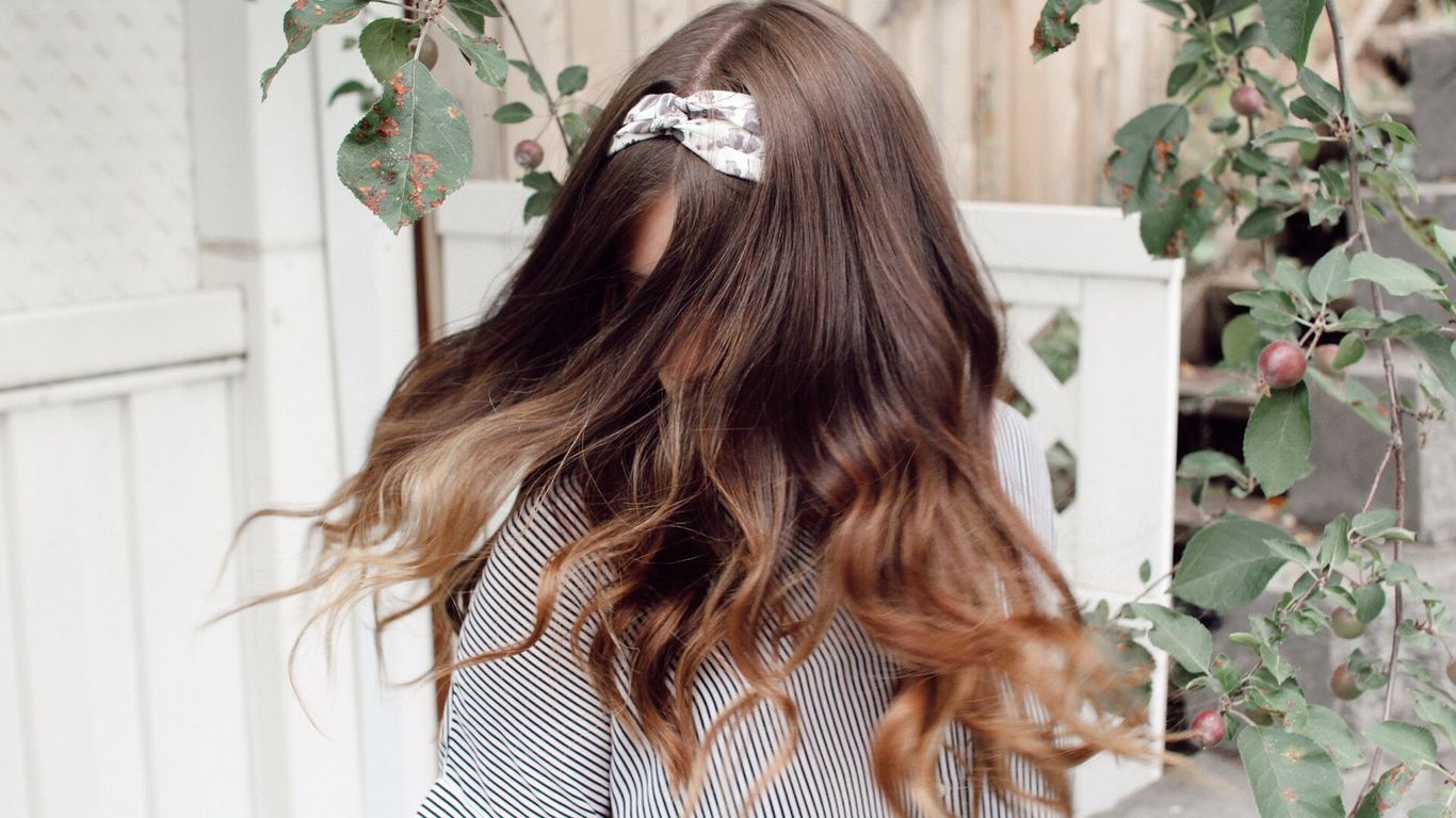 Hair flip captured in motion, nature background, aesthetic vibe.