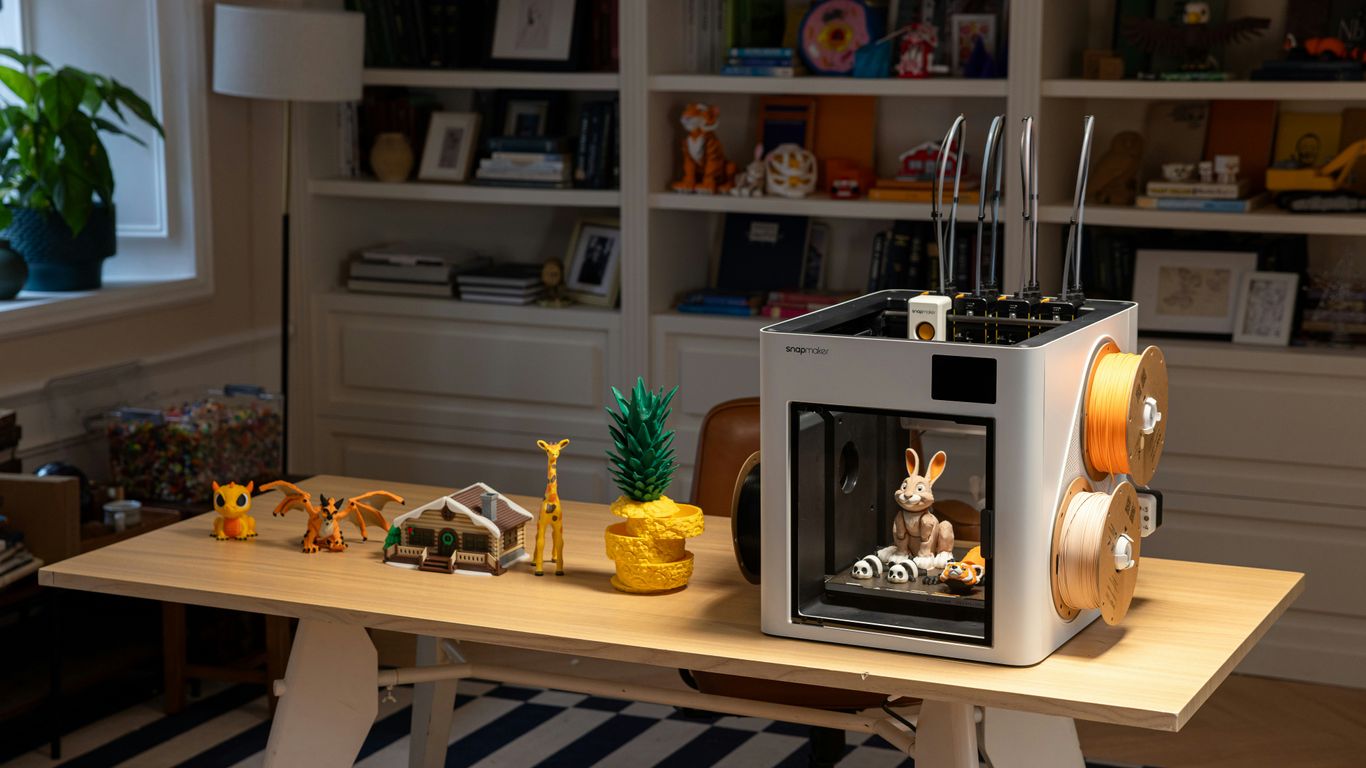 3D printer with filament and printed objects on desk