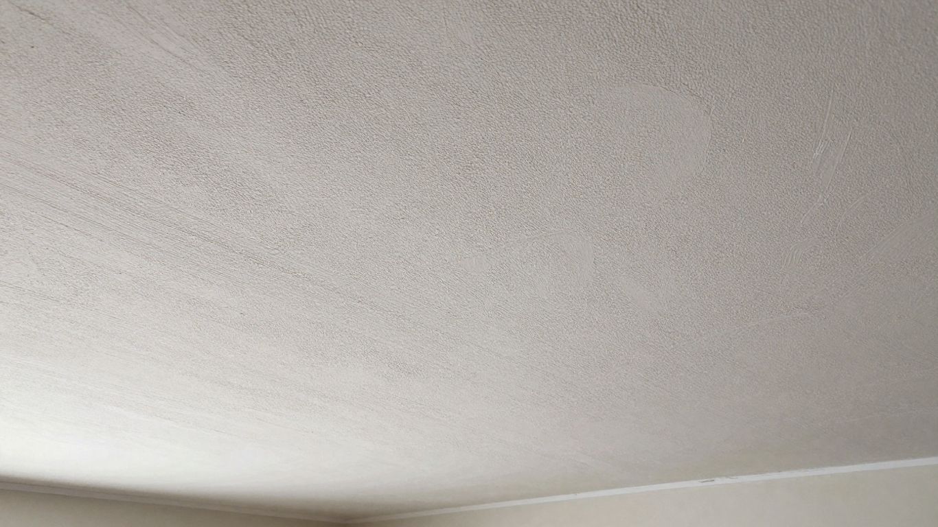 Artex ceiling being skimmed to a smooth finish.