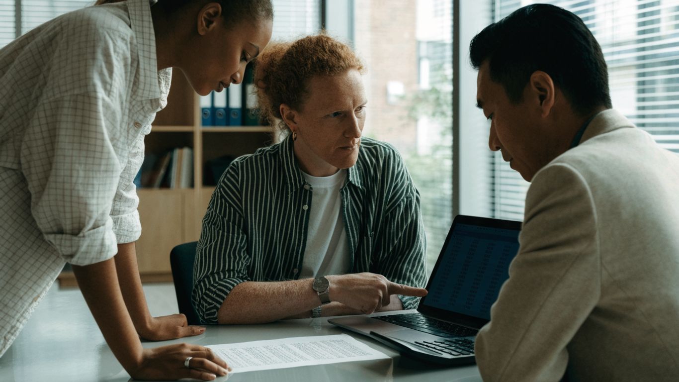Finance team reviewing bank data on screen