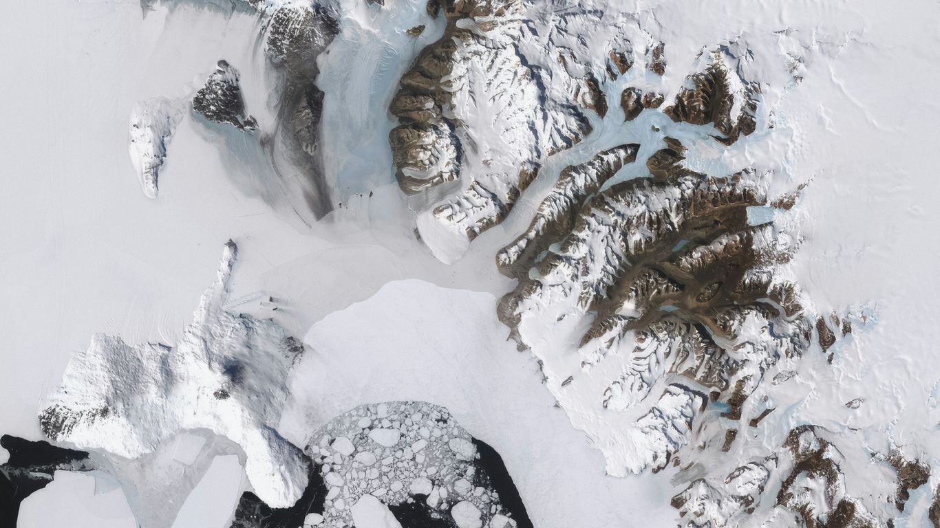 An aerial view of snow covered mountains and lakes