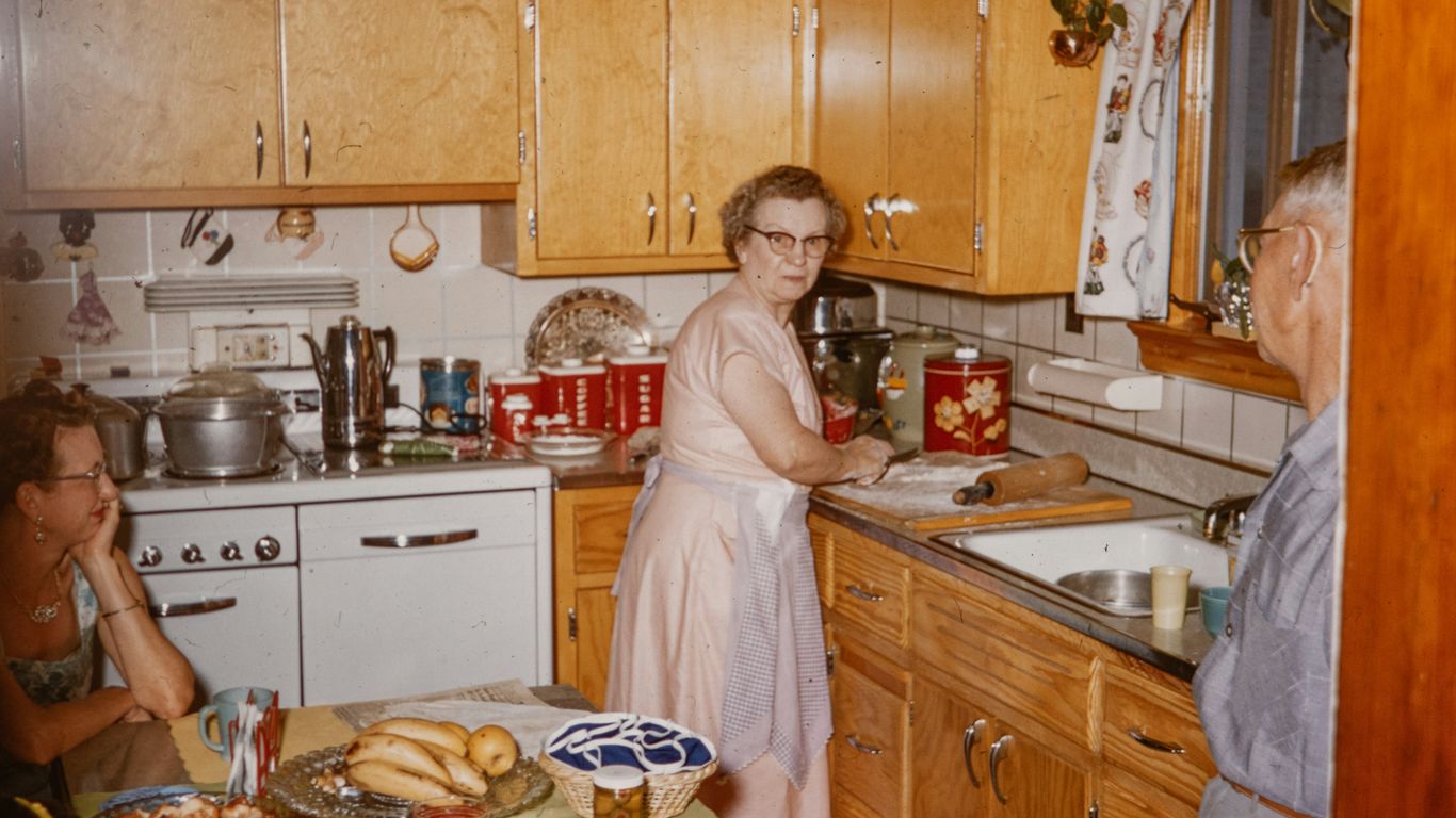 a woman standing in a kitchen next to a man