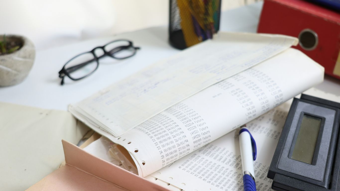 Desk with papers, glasses, calculator, and office supplies
