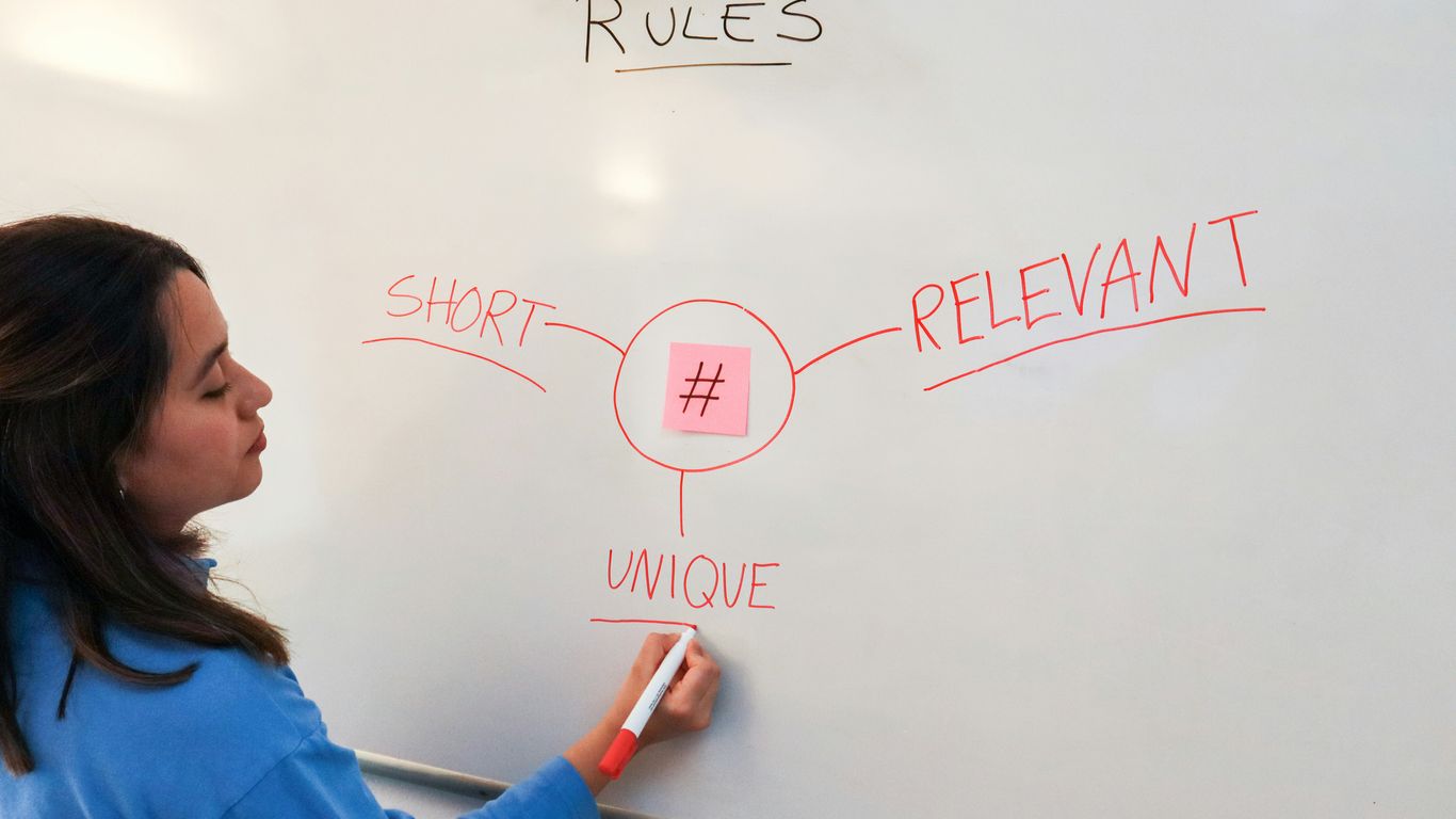 a woman writing on a whiteboard with a marker