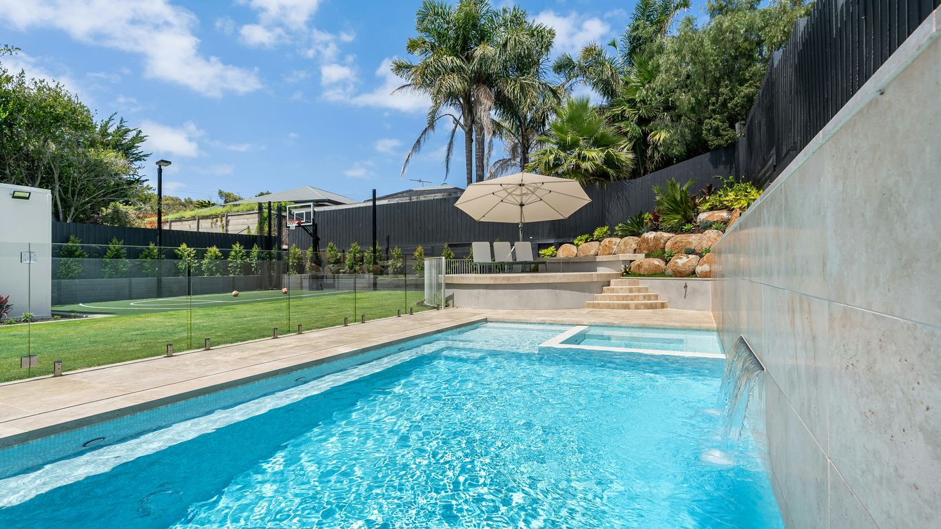 A swimming pool in a backyard with a fenced in area
