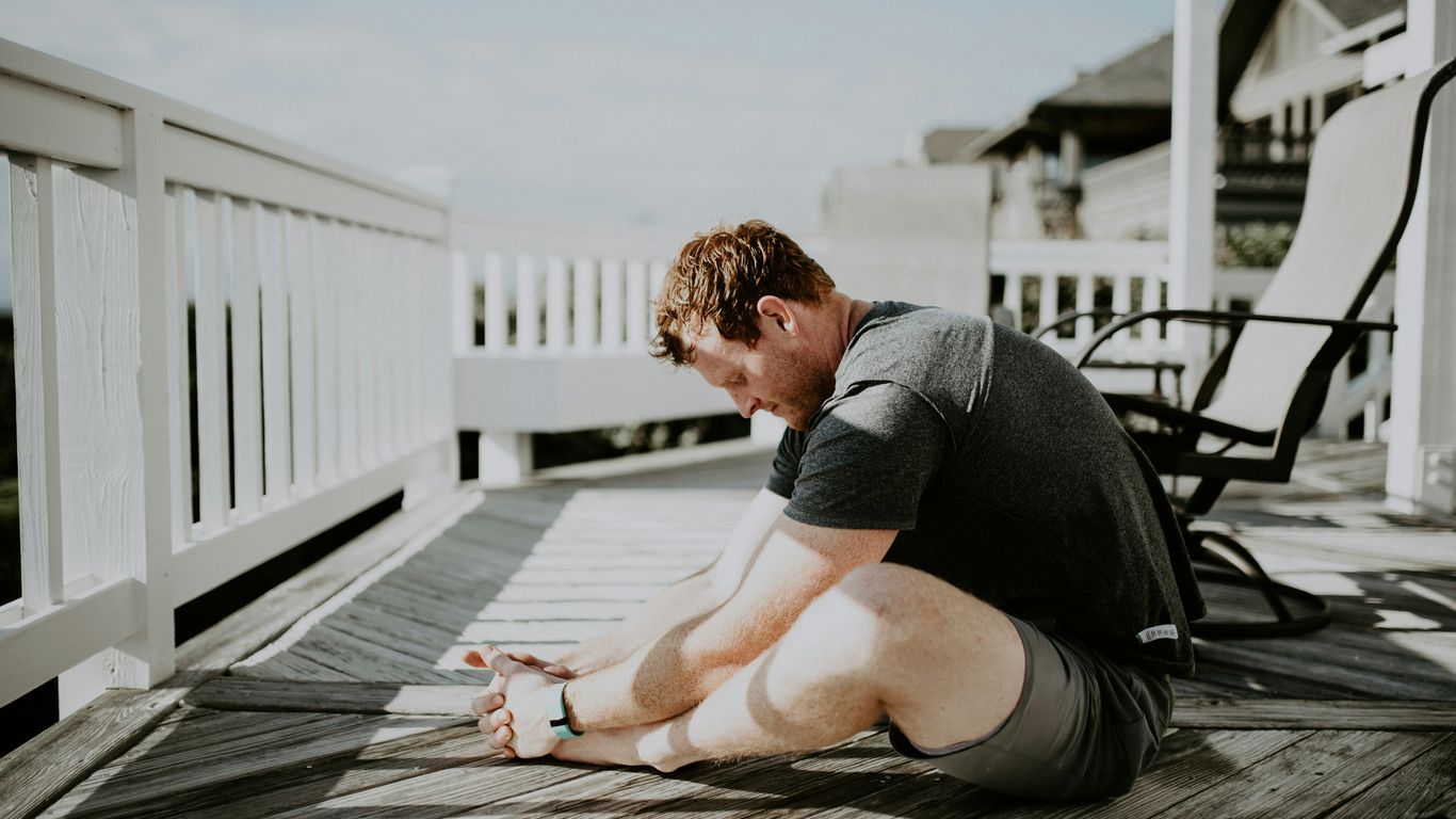 man doing yoga in porch