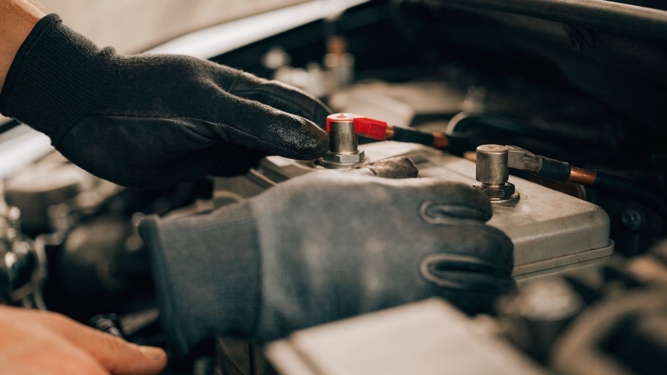 Technician inspecting a car battery and terminals