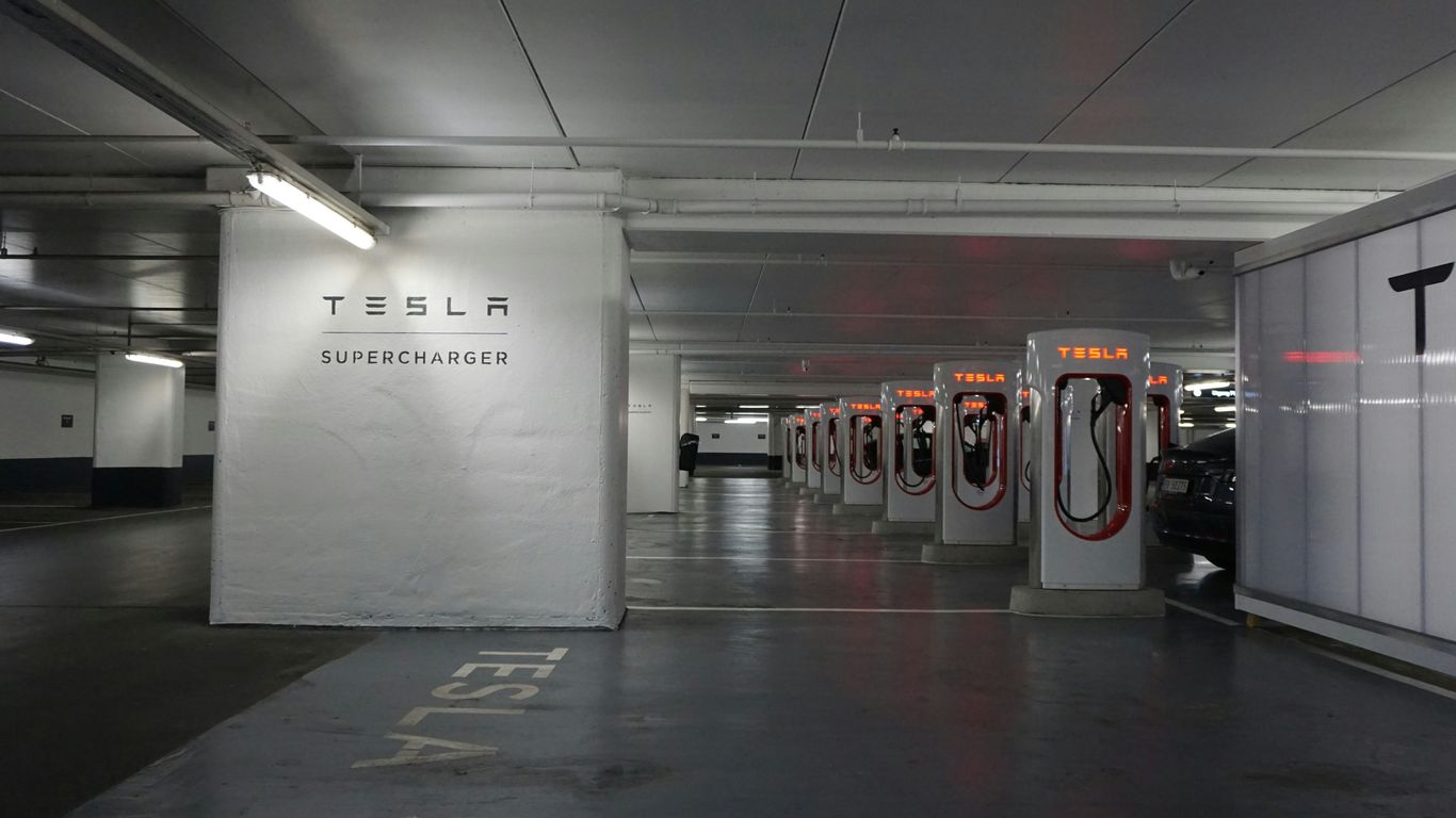 a parking garage with a row of electric cars