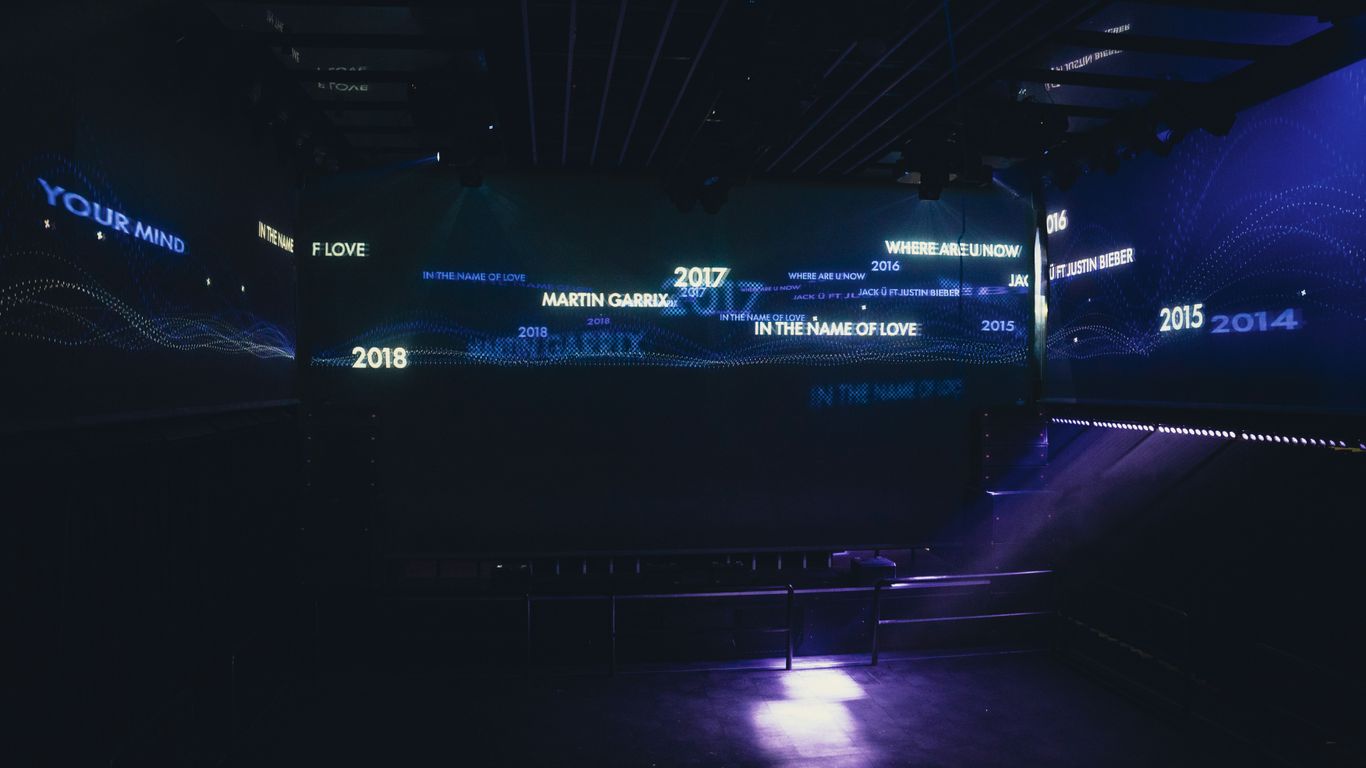 a dark room with blue lights and a large screen