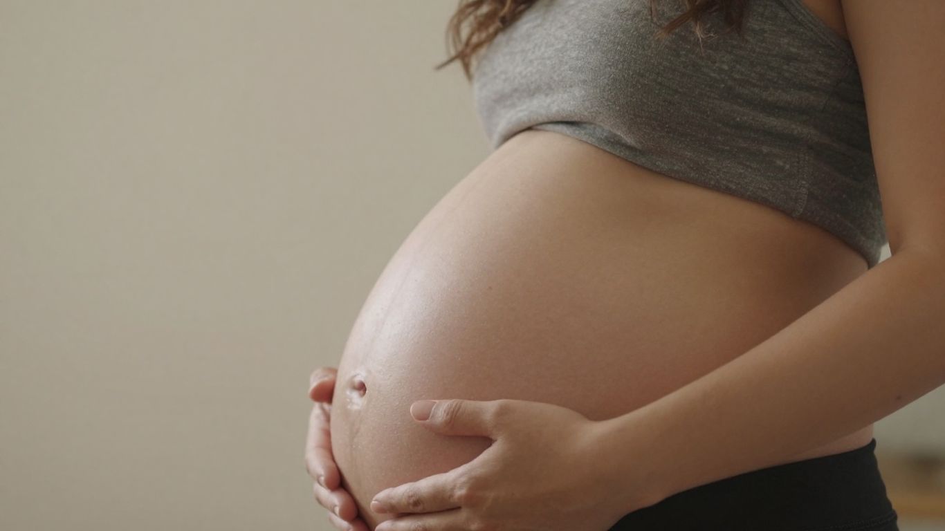 Mujer embarazada de 36 semanas acariciando su vientre.