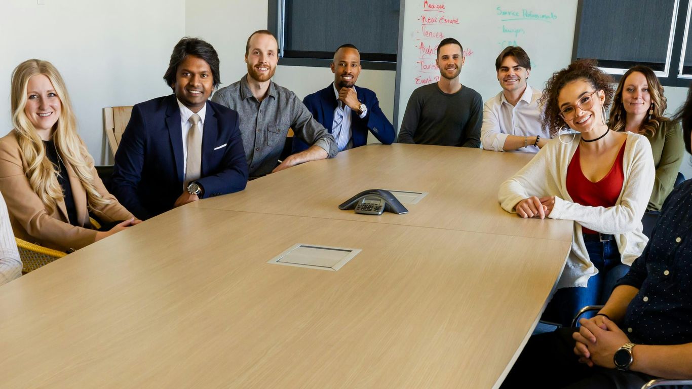 group of people sitting on chair in front of brown wooden table