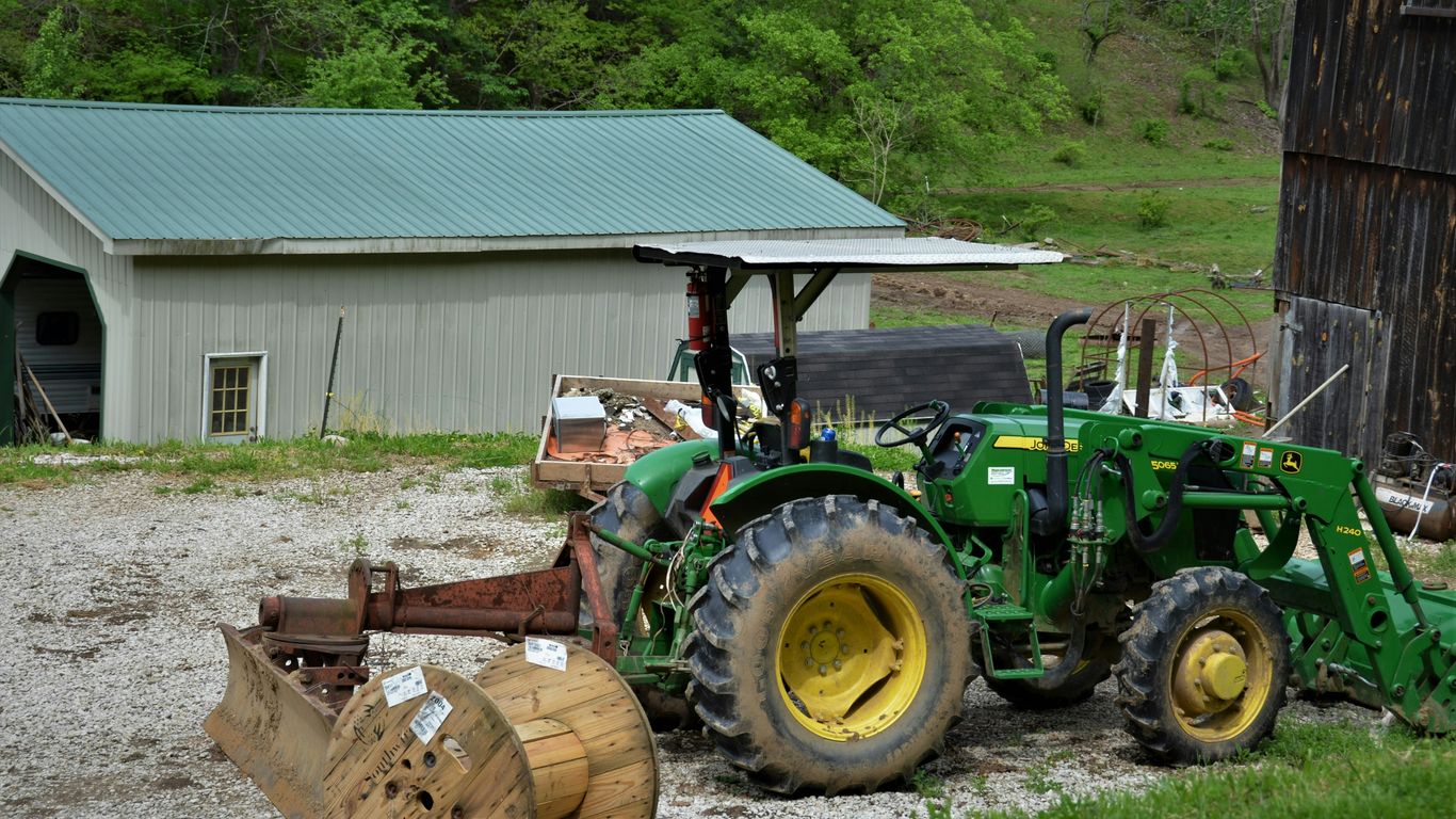 green and yellow tractor on green grass field during daytime
